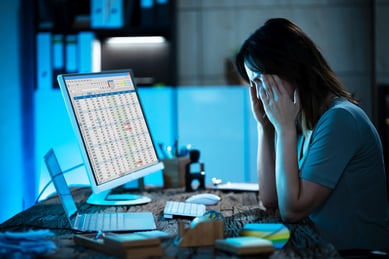 stressed event marketer working late on data entry and reporting